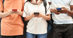 Three young people seen up close using their cell phones